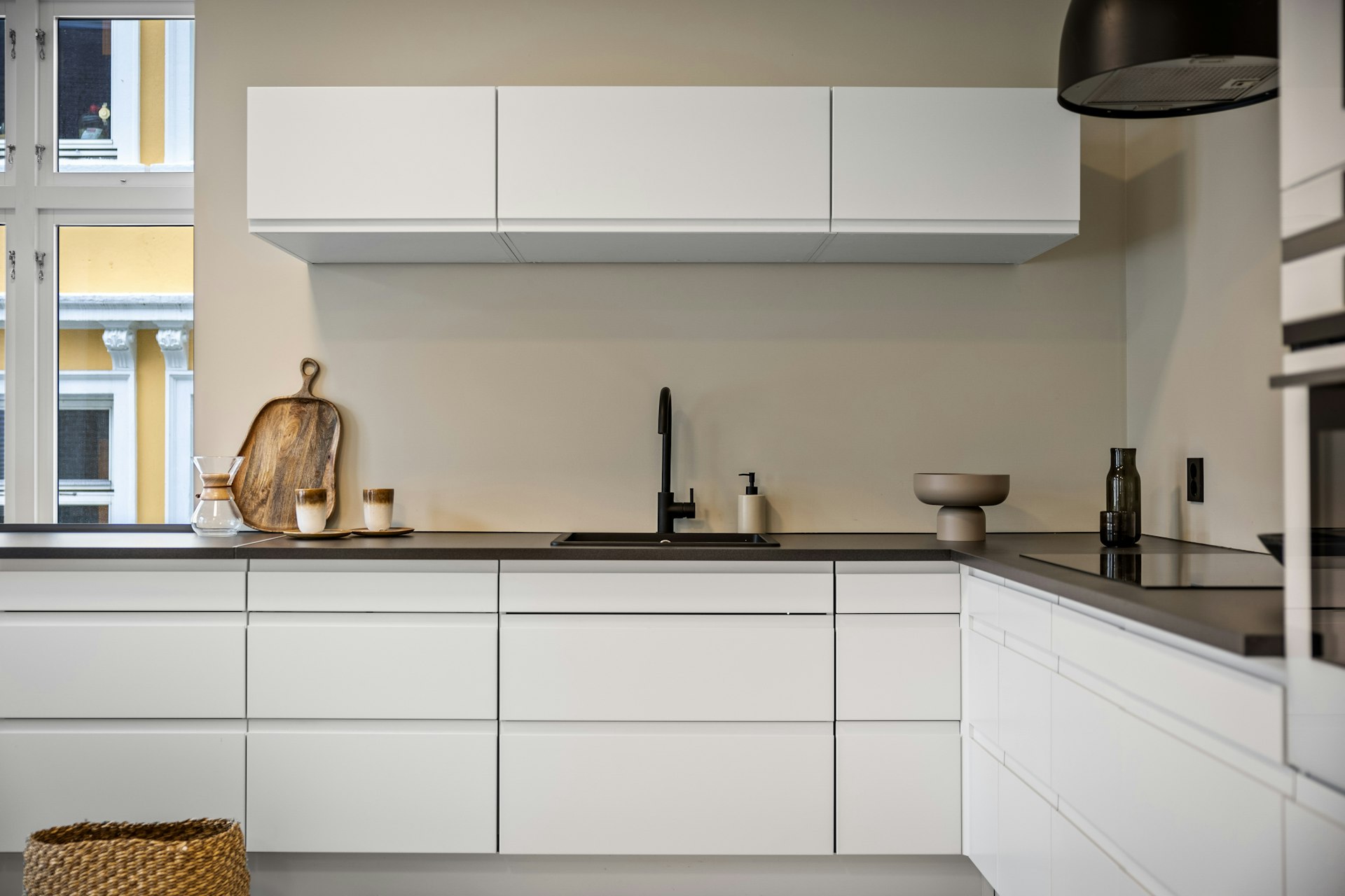 A kitchen with white cabinets and a window